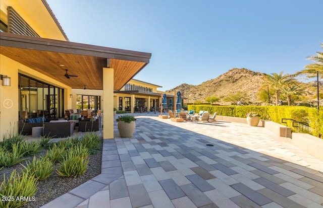 view of patio featuring an outdoor hangout area, ceiling fan, and a mountain view