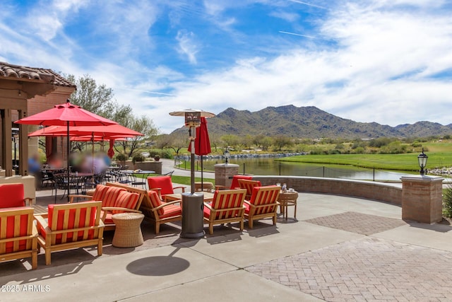 view of patio featuring a water and mountain view and a grill