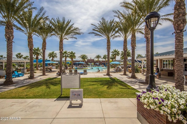 view of community featuring a swimming pool and a lawn