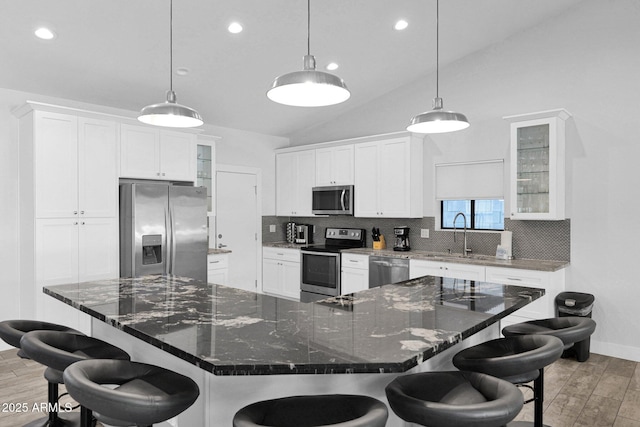 kitchen with a breakfast bar area, backsplash, and appliances with stainless steel finishes