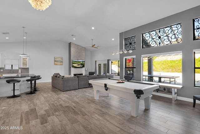 recreation room featuring a stone fireplace, high vaulted ceiling, and pool table