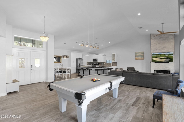 rec room featuring a fireplace, high vaulted ceiling, ceiling fan, and pool table