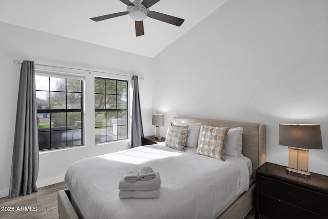 bedroom featuring hardwood / wood-style floors, ceiling fan, and lofted ceiling