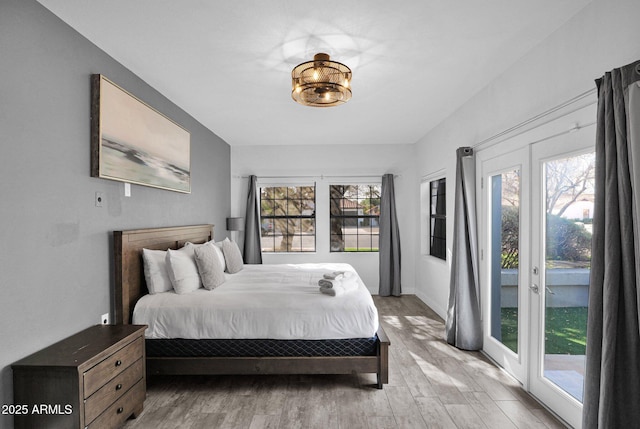 bedroom with access to exterior and light wood-type flooring