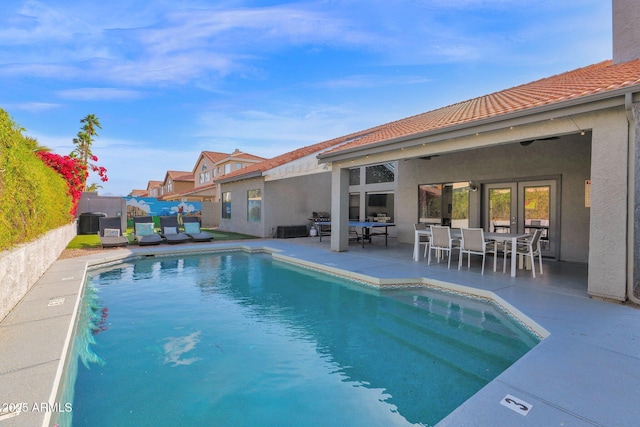 view of swimming pool with central AC unit and a patio