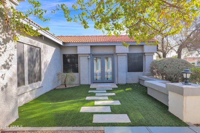 doorway to property with a lawn and french doors