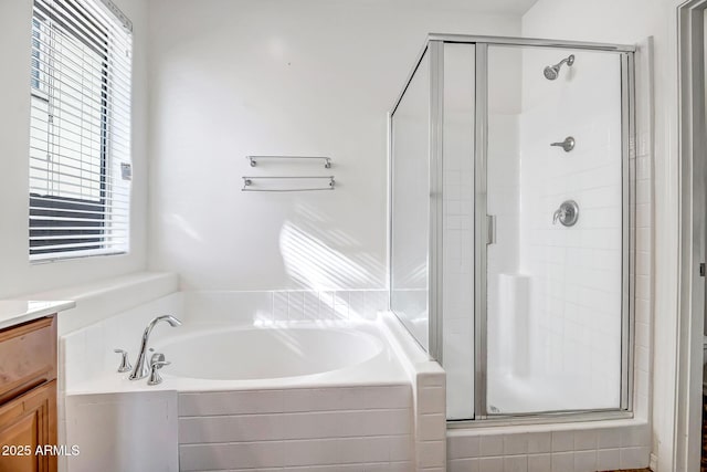 bathroom featuring vanity, a shower stall, and a bath