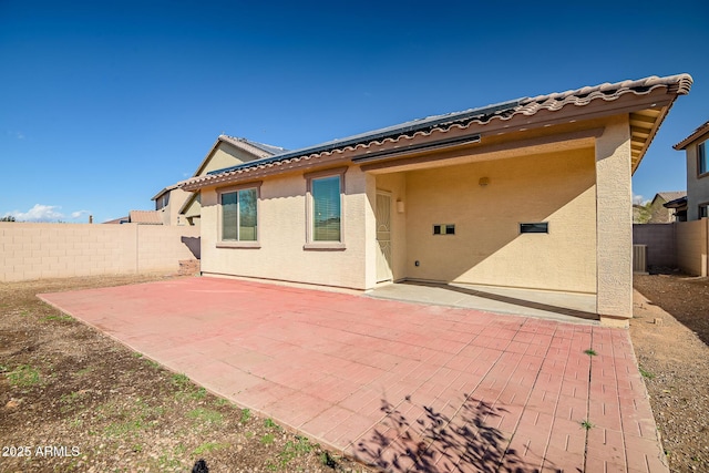 rear view of property featuring a patio area, a fenced backyard, a tiled roof, and stucco siding