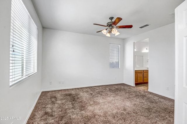 unfurnished bedroom with carpet, visible vents, ensuite bathroom, ceiling fan, and baseboards