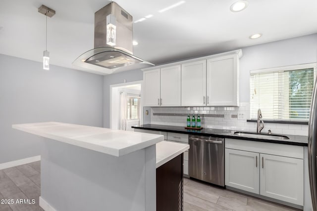 kitchen featuring sink, decorative light fixtures, stainless steel dishwasher, island exhaust hood, and white cabinets