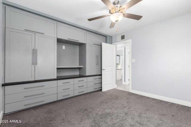 unfurnished bedroom featuring dark carpet and ceiling fan