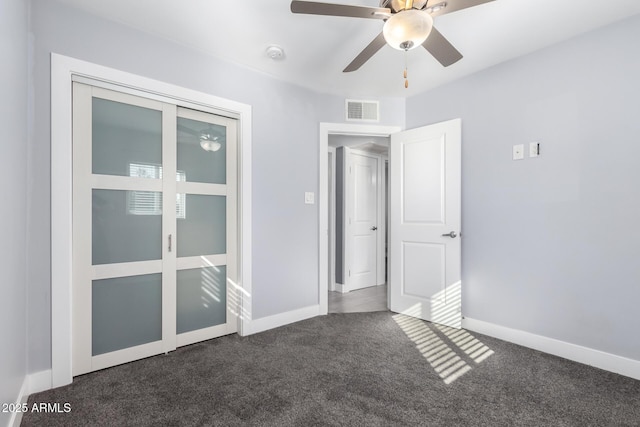 unfurnished bedroom featuring a closet, ceiling fan, and dark colored carpet