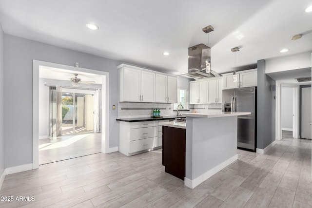 kitchen featuring white cabinetry, tasteful backsplash, light hardwood / wood-style floors, stainless steel fridge with ice dispenser, and decorative light fixtures