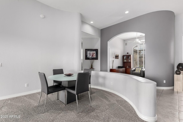 carpeted dining room with ceiling fan