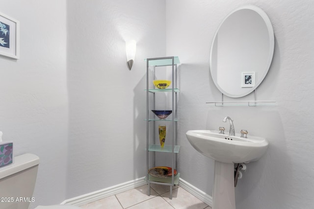 bathroom featuring toilet, tile patterned flooring, and sink