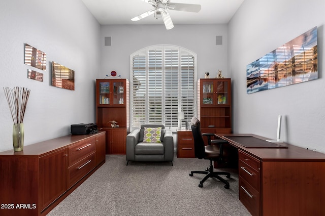 carpeted office space with ceiling fan