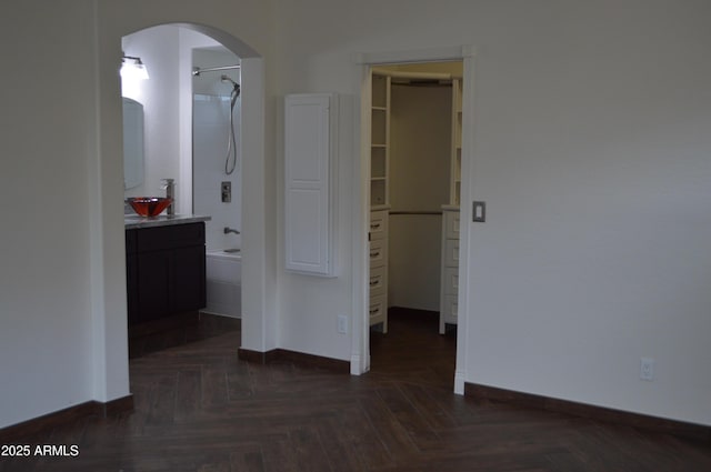 6620 W Shaw Butte Dr, Glendale, AZ 85304 - unfurnished bedroom with baseboards, arched walkways, a walk in closet, and ensuite bathroom