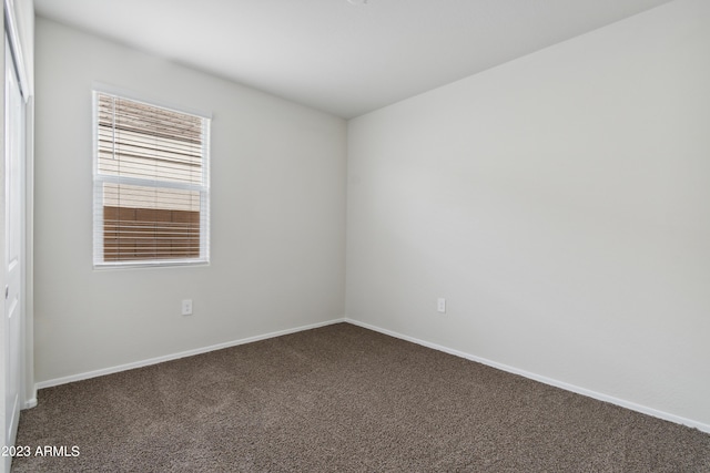 spare room with dark carpet