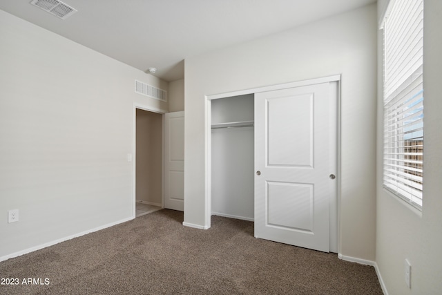 unfurnished bedroom with a closet and carpet flooring