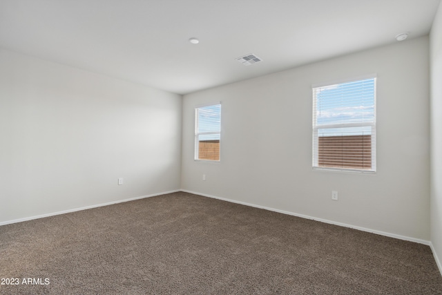 spare room featuring dark carpet