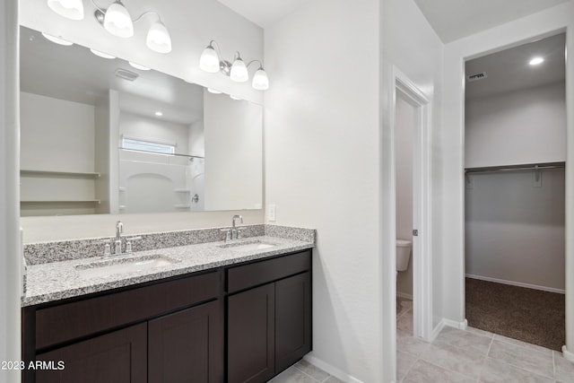 bathroom featuring toilet, vanity, and a shower