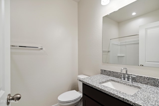 bathroom with toilet, walk in shower, and vanity