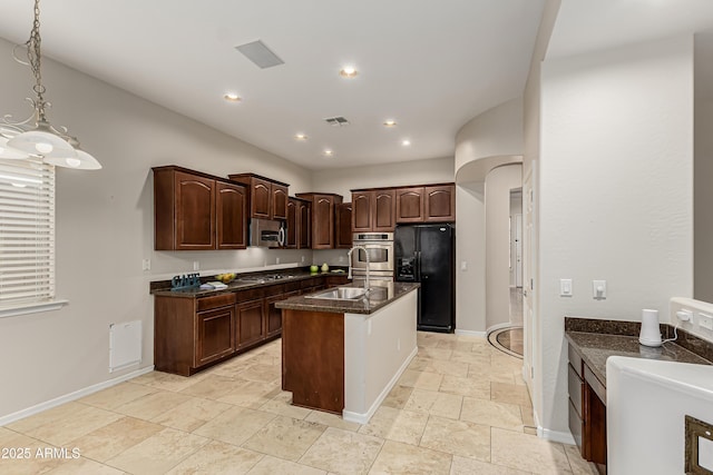 kitchen with appliances with stainless steel finishes, pendant lighting, sink, a center island, and dark brown cabinets