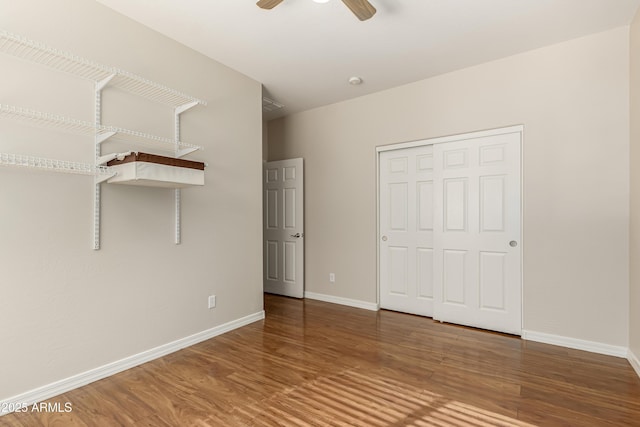 unfurnished bedroom with ceiling fan, wood-type flooring, and a closet