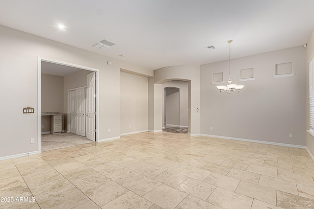 spare room with a chandelier