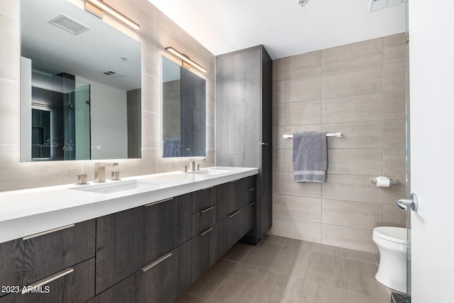 bathroom featuring tile walls, vanity, tile patterned floors, and toilet