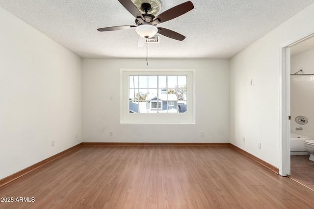 interior space featuring ceiling fan, light hardwood / wood-style floors, and a textured ceiling