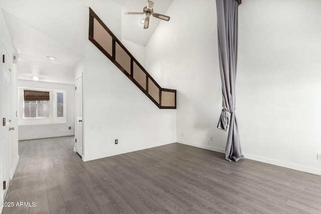 unfurnished living room with ceiling fan, dark hardwood / wood-style floors, and high vaulted ceiling