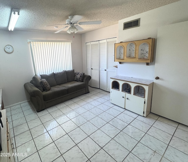 8552 E Via Del Palacio, Scottsdale, AZ 85258 - living room featuring light tile patterned floors, ceiling fan, a textured ceiling, and visible vents