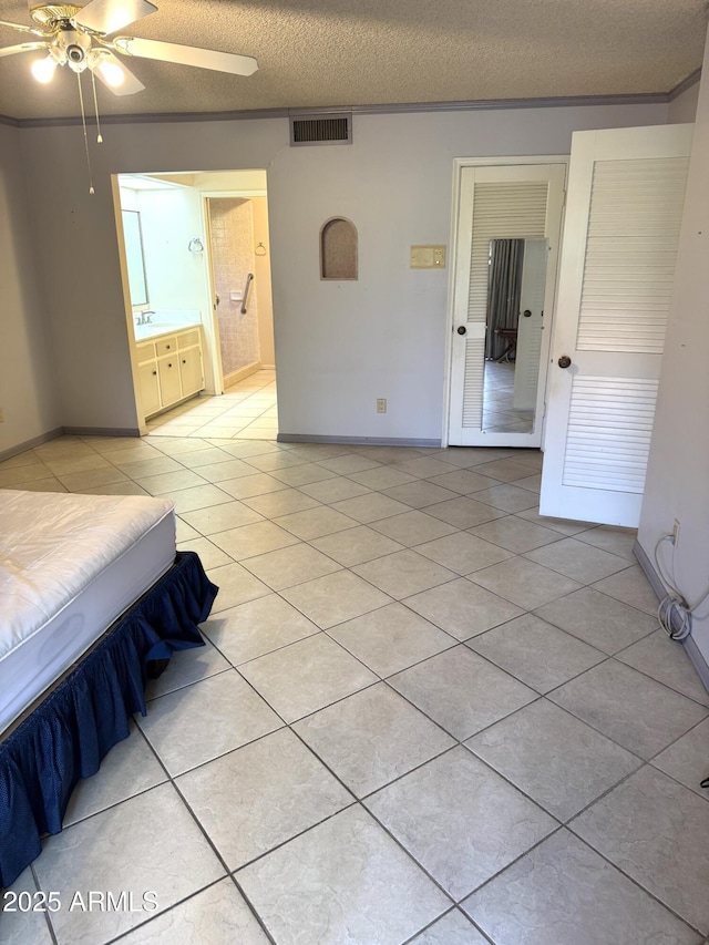 8552 E Via Del Palacio, Scottsdale, AZ 85258 - unfurnished bedroom featuring visible vents, light tile patterned flooring, baseboards, a textured ceiling, and connected bathroom