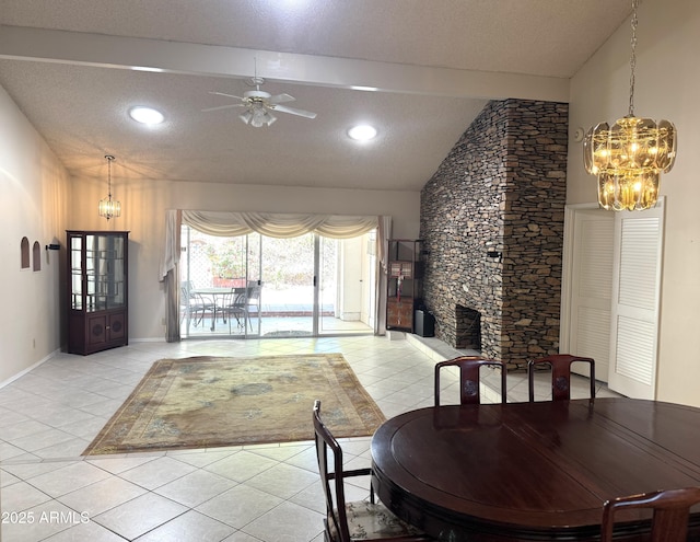 8552 E Via Del Palacio, Scottsdale, AZ 85258 - dining room with a textured ceiling, a stone fireplace, ceiling fan with notable chandelier, light tile patterned floors, and vaulted ceiling