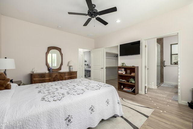 bedroom with a closet, ceiling fan, a spacious closet, light hardwood / wood-style flooring, and ensuite bathroom