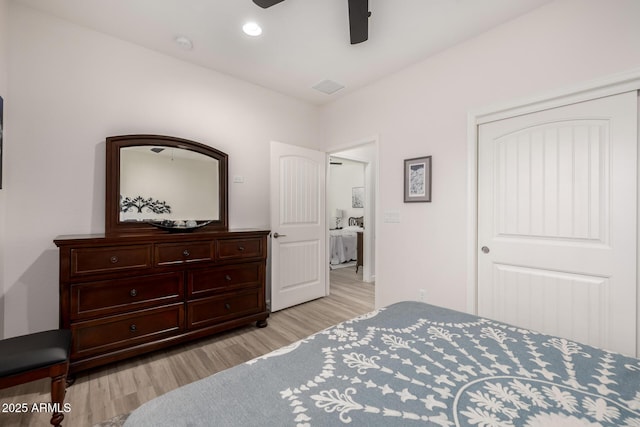 bedroom with ceiling fan, light hardwood / wood-style flooring, and a closet