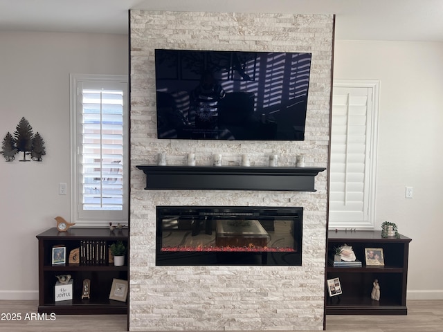 interior details featuring hardwood / wood-style flooring and a stone fireplace