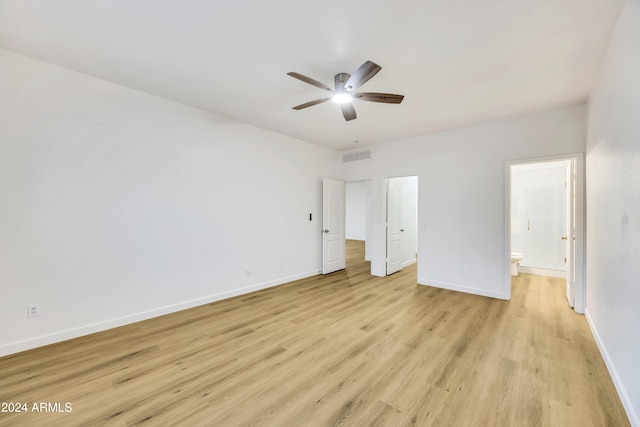 unfurnished bedroom featuring connected bathroom, ceiling fan, and light hardwood / wood-style flooring