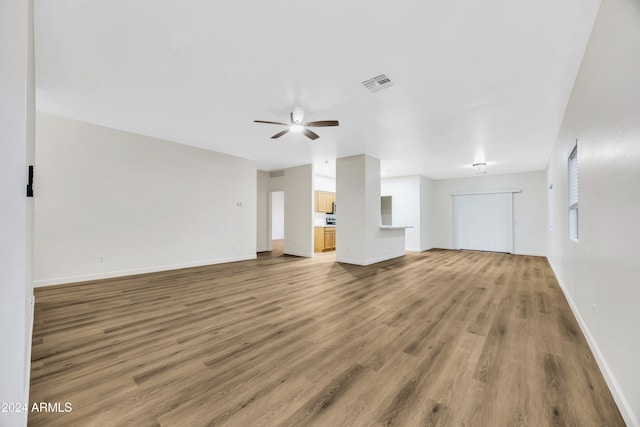 unfurnished living room featuring hardwood / wood-style flooring and ceiling fan