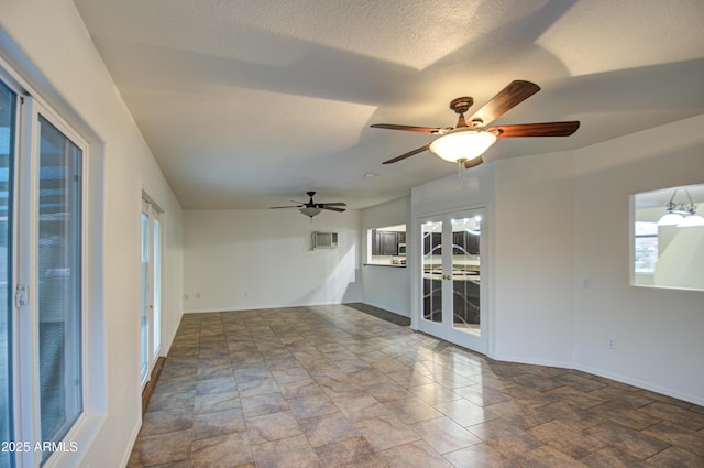 unfurnished room featuring french doors, a textured ceiling, and a wealth of natural light