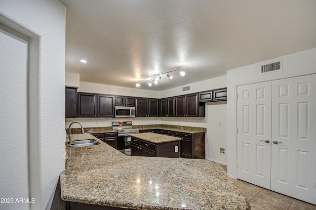 kitchen with dark brown cabinetry, sink, light stone counters, kitchen peninsula, and stainless steel appliances