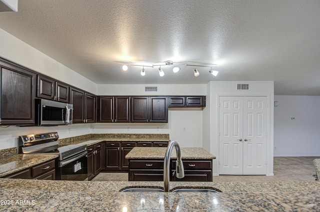 kitchen featuring light stone counters, appliances with stainless steel finishes, sink, and dark brown cabinets