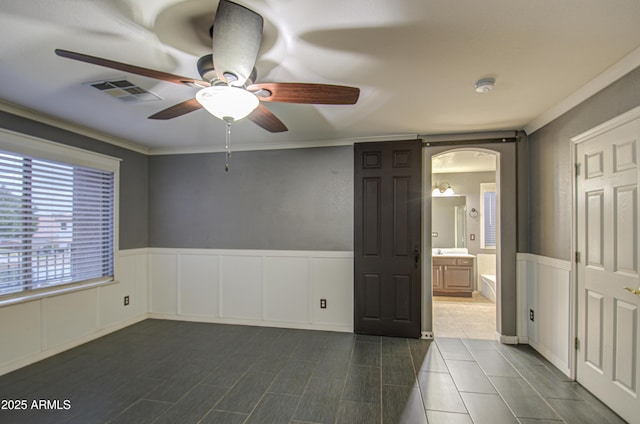 unfurnished room with ornamental molding and ceiling fan