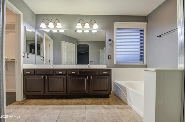 bathroom featuring tile patterned flooring, a bath, and vanity