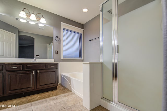 bathroom with tile patterned flooring, vanity, and separate shower and tub