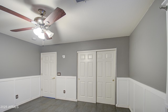 unfurnished bedroom featuring ceiling fan and dark hardwood / wood-style floors