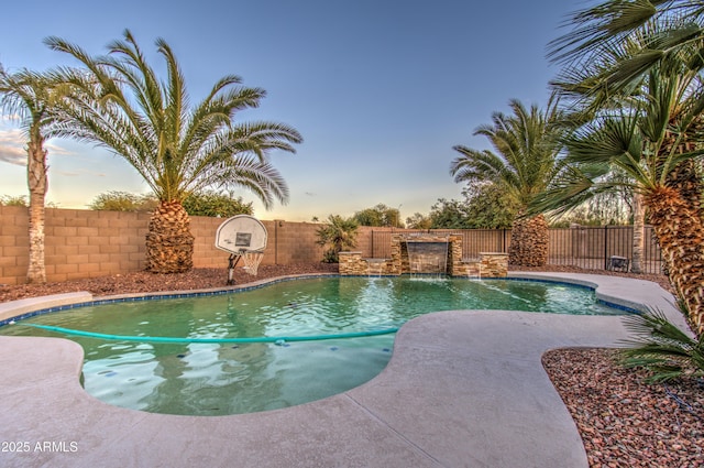 pool at dusk with pool water feature