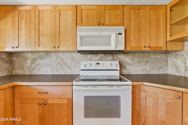 kitchen featuring white appliances, dark countertops, and decorative backsplash