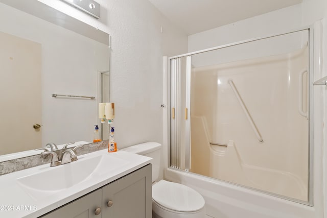 full bathroom featuring bath / shower combo with glass door, vanity, and toilet